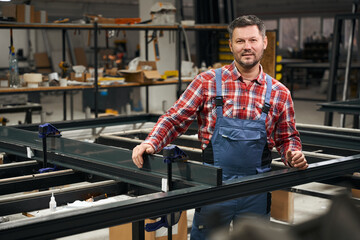 Obraz premium Portrait of man connecting metal parts in factory