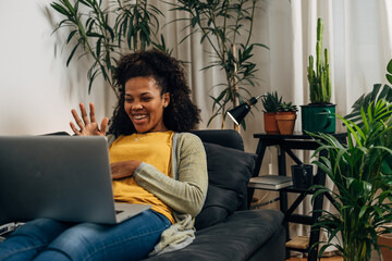 Cheerful middle aged woman is having a video call at home