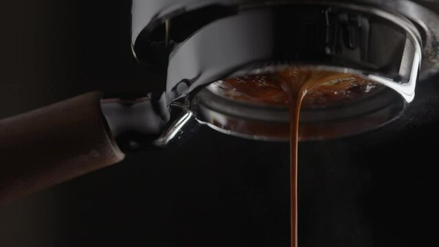 Slow motion pull espresso shot with bottomless portafilter on a professional coffee machine