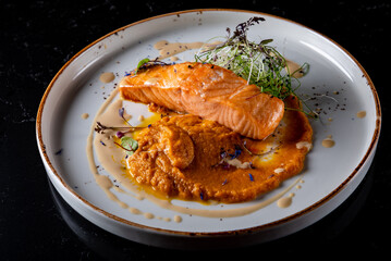 Roasted salmon steak with pumpkin cream on plate