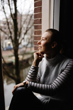 Young girl admiring of city view while resting at home