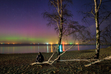 Man watching aurora over the Baltic Sea in Gdansk, Poland.