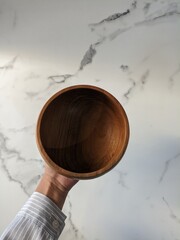 Girl hand holding wooden bowl