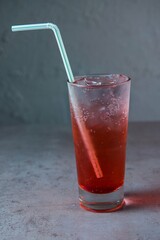 Healthy Shirley Temple soda served in glass with straw side view on grey background
