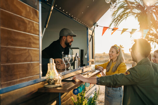Content people talking with worker near food truck