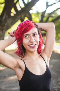 Person with pink hair and armpit hair