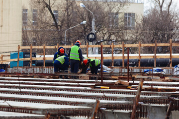 Workers in protective helmets are repairing bridge in Voronezh