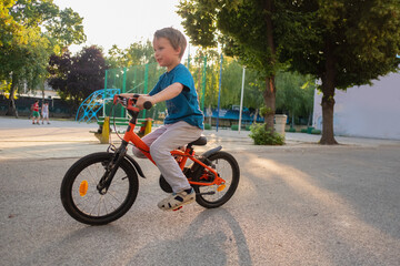 One blonde boy riding a bicycle 