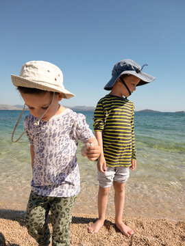 Kids wearing sunhats and long sleeves at the beach