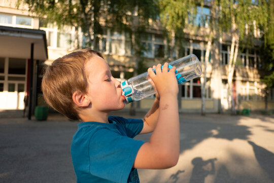 A child drinks water outdoors