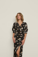 Serie of studio photos of young female model in dark floral silk satin midi dress.	