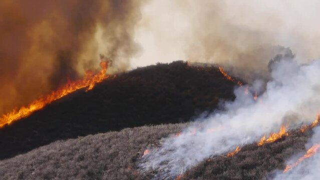 2022 - Excellent drone footage of smoke and flames rising from lines of controlled burns along a hilly field in Santa Barbara, California.