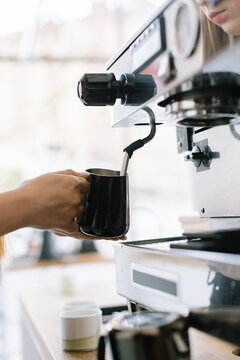 Milk for Cappuccino is Flowing from Coffee Machine