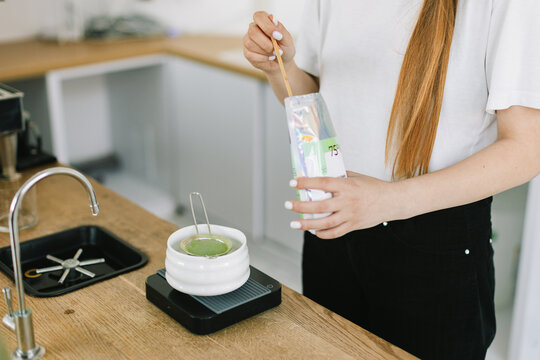 Barista Making Matcha Tea in White Bowl