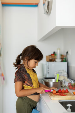 young little girl cutting veggies 