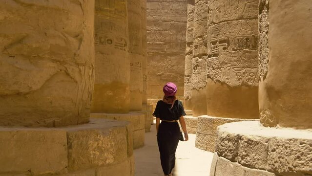 2022 - A tourist walks among the columns of Egypt's Karnak Temple Complex.