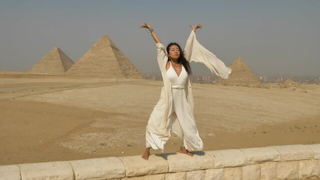 2022 - An interpretive dancer performs in the breeze before pyramids in Egypt.