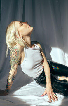 PORTRAIT OF A BLONDE GIRL LYING OVER A WHITE BACKGROUND AND SUNLIGHT