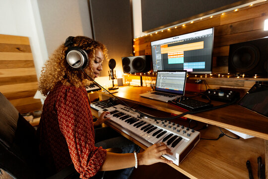 Music producer at home studio using keyboard controller