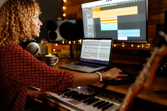 happy Music producer working at home studio using midi pad controller