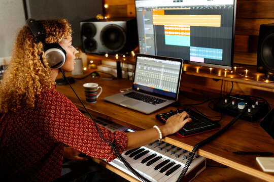 happy Music producer working at home studio using mini pad controller - Powered by Adobe