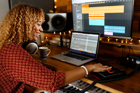 happy Music producer working at home studio using midi pad controller