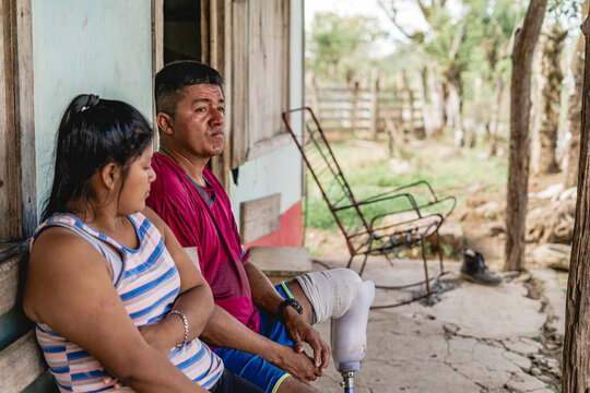 Couple sitting outside their home.