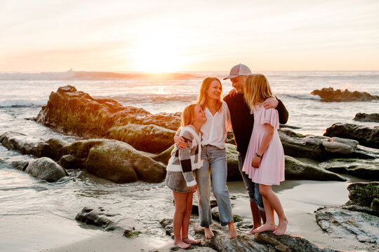 Smiling family hugging at the beach