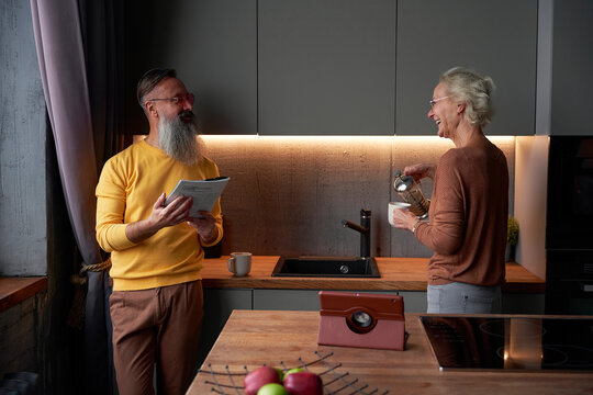 Positive Senior Couple Chatting In Kitchen
