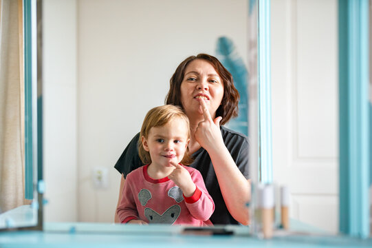  kid and mature mother exercises facial expressions 