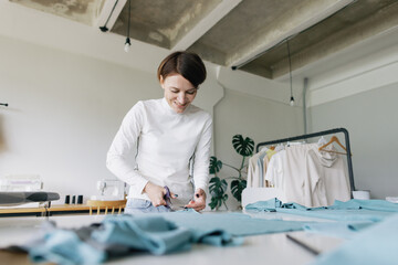 Happy couturier. Workshop interior. Scissors. Fabric. At work