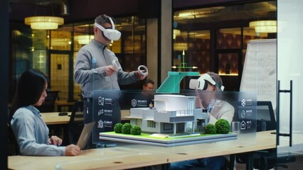 Male designer uses VR headset and wireless controllers, presents smart home exterior design project in virtual reality to coworkers. Modern hi-tech company. 3D hologram. Future digital technologies. - Powered by Adobe