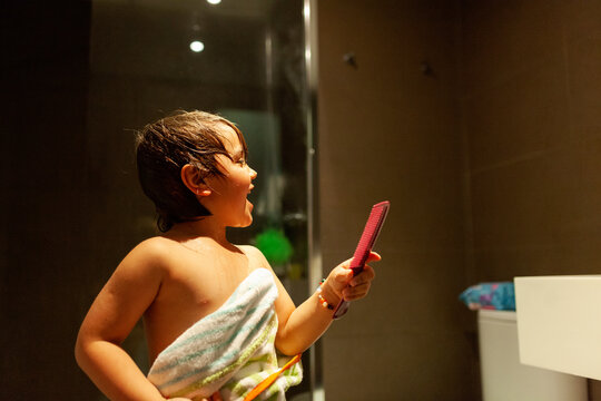 Boy after showering combing his hair