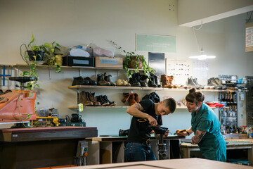 Two people working in a shoe repair shop.