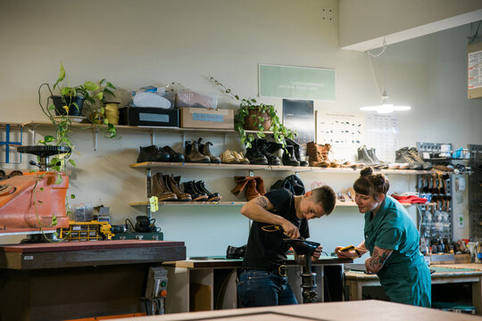 Two people working in a shoe repair shop.