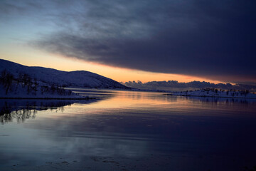 landscape sunset in snowy nature and sea in tromso