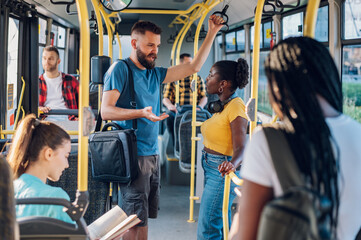 Multiracial friends talking while riding a bus in the city