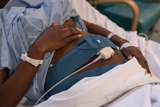 Pregnant black woman with CTG scanner on belly