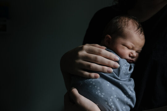 Newborn being held by mother.
