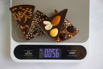 Chocolate, kitchen scales on a light background