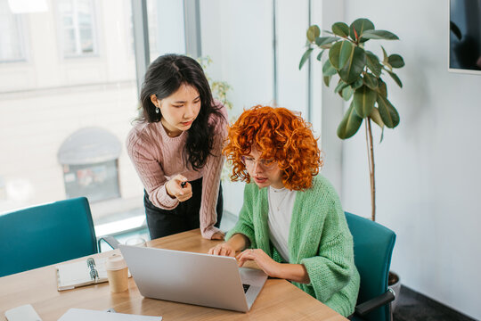 Two women use laptops