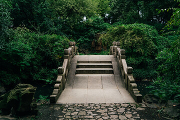 Stone bridge amidst lush bushes
