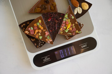 Chocolate, kitchen scales on a light background
