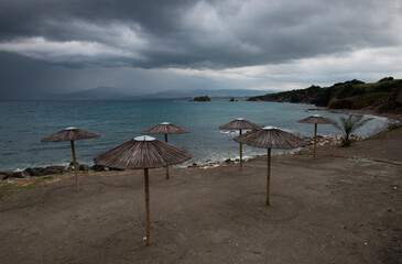  Beach umbrellas at a rocky coast in winter. Summer vacations