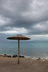  Beach umbrellas at a rocky coast in winter. Summer vacations