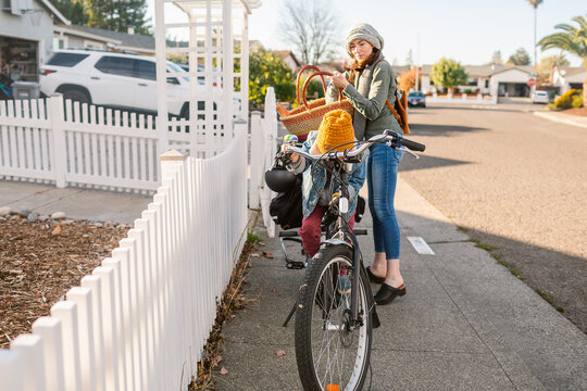 Woman with parked bicycle leaving home in autumn