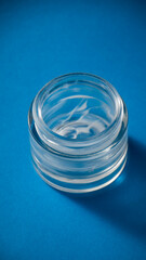 Tarro pequeño de cristal con restos de crema facial