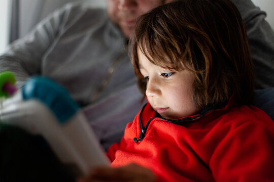 dad playing tablet with his son