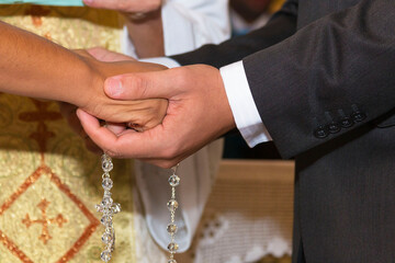 Obraz premium Mãos do noivo e da noiva no momento da cerimonia de casamento.