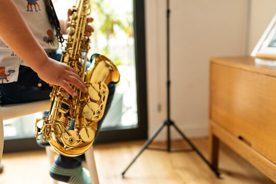 faceless kid playing saxophone
